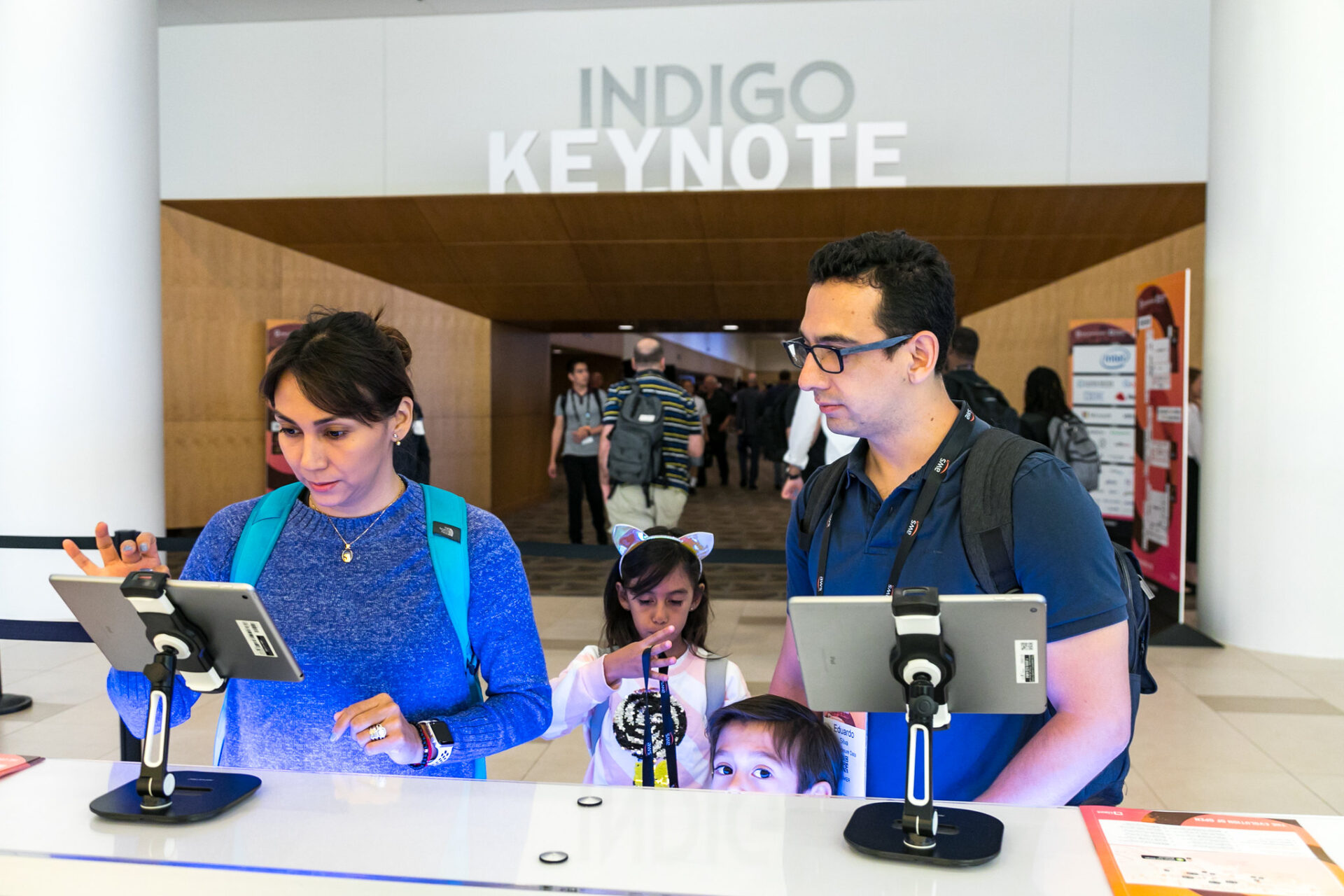 A couple with kids completing registration using an Ipad before event starts