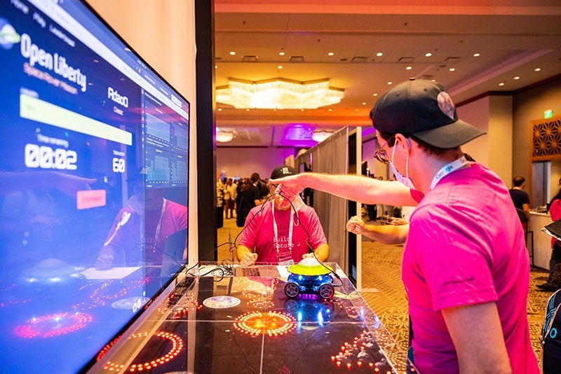 Event sponsors promotion team in pink shirts showcasing their technology to attendees 