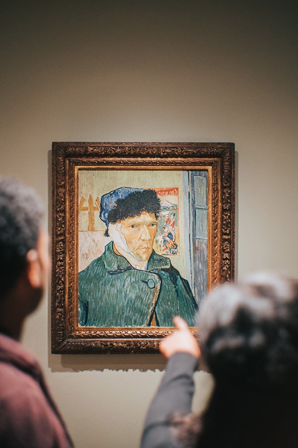 Two art critics looking at a painting by Van Gogh