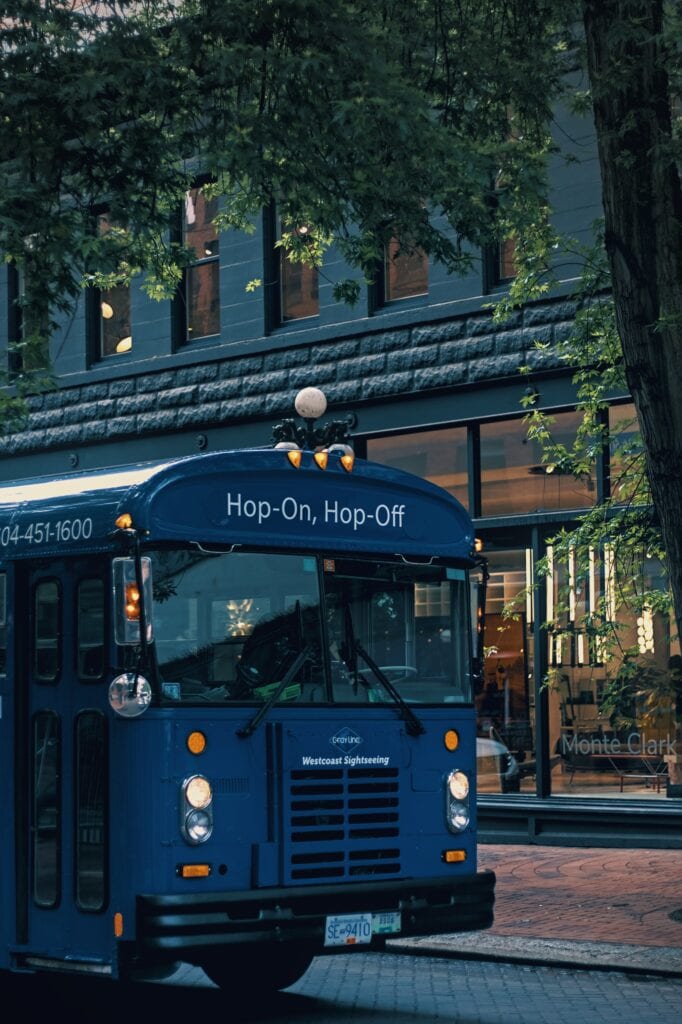Dark blue bus with the words "Hop On, Hop Off" above the bus driver's window.