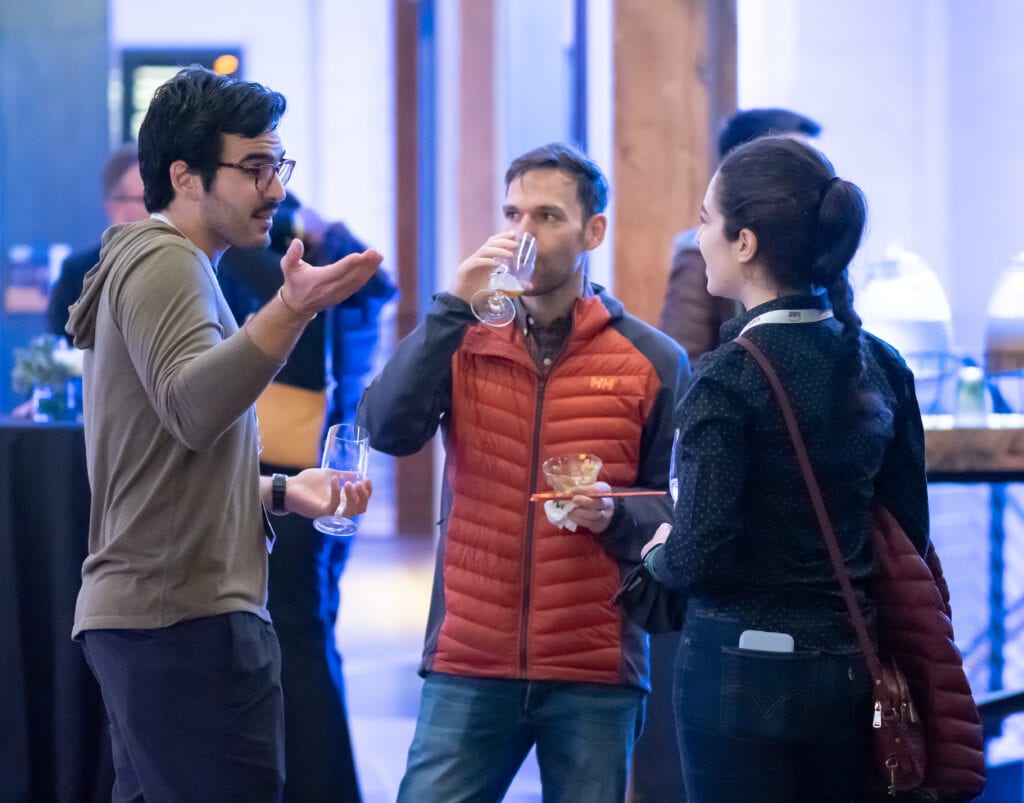 Two men and a woman having a conversation and drinks