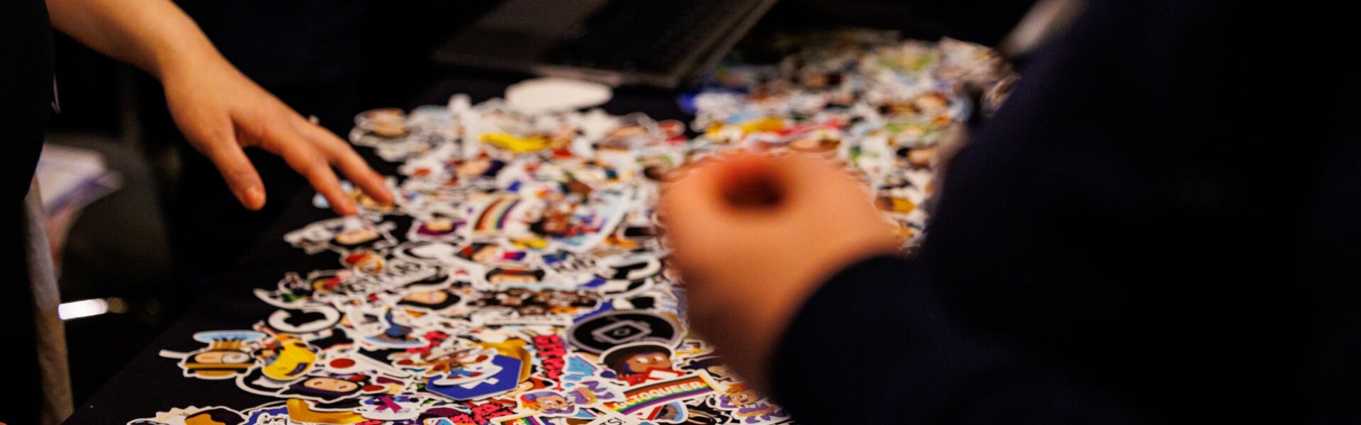 A pile of colorful stickers spread out on a table.