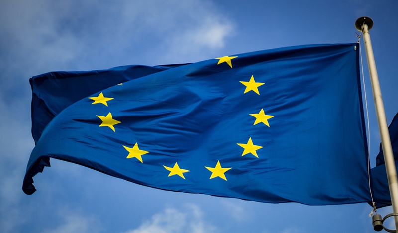 The European flag with a blue sky behind it.