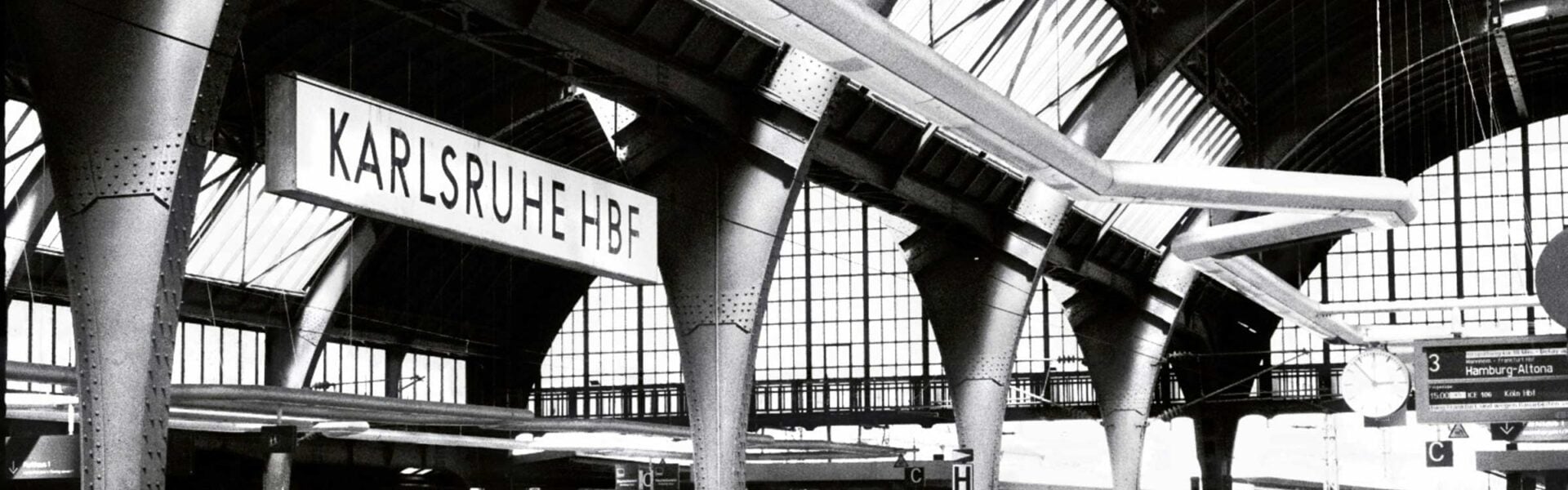 Sign that says Karlsruhe HBF in a transportation station.