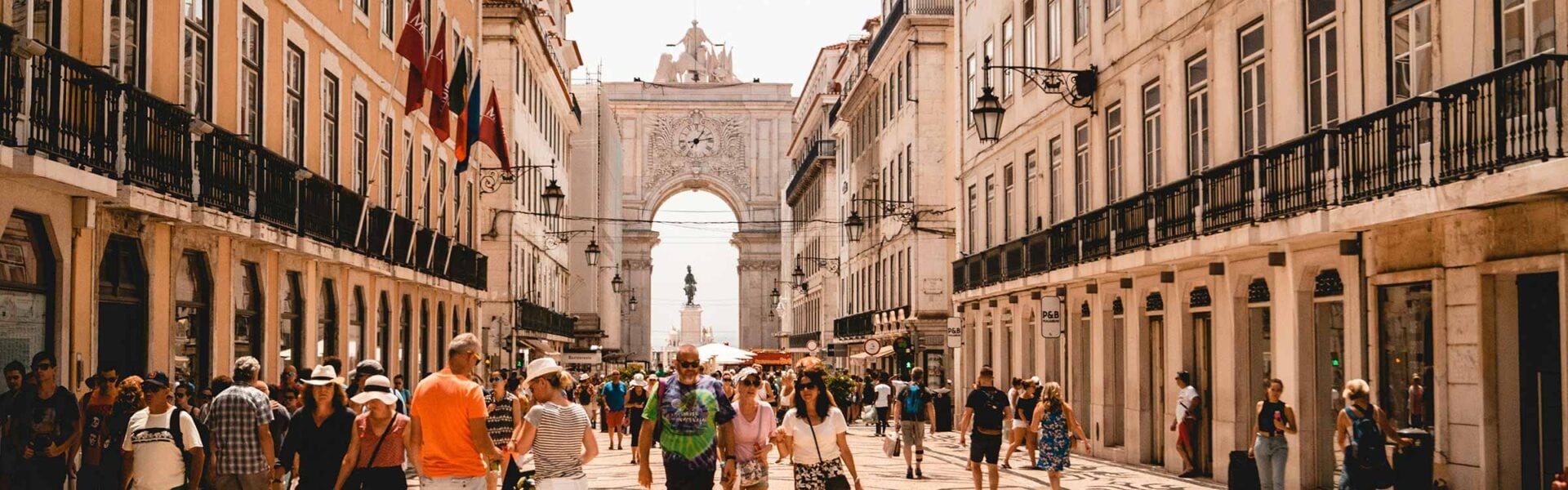 A crowd of people walking down a street in Lisbon, Portugal.