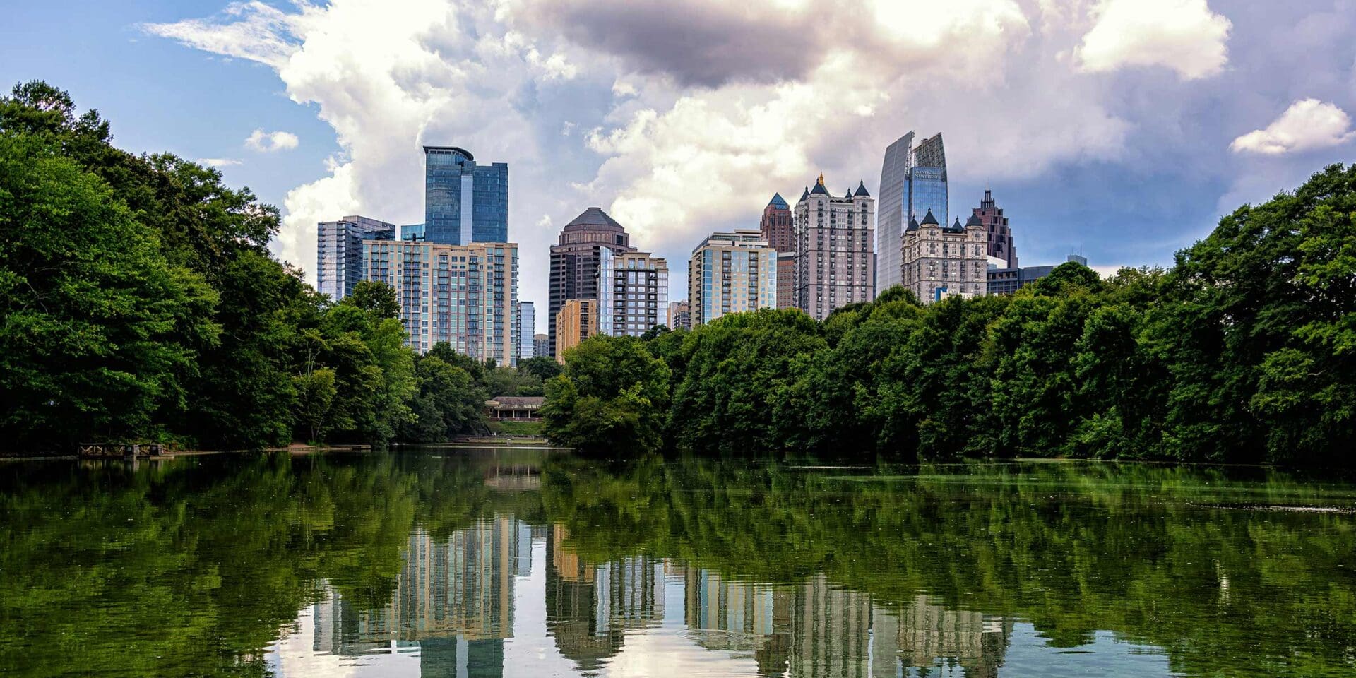 The city of Atlanta with a lake reflecting the buildings in the foreground.