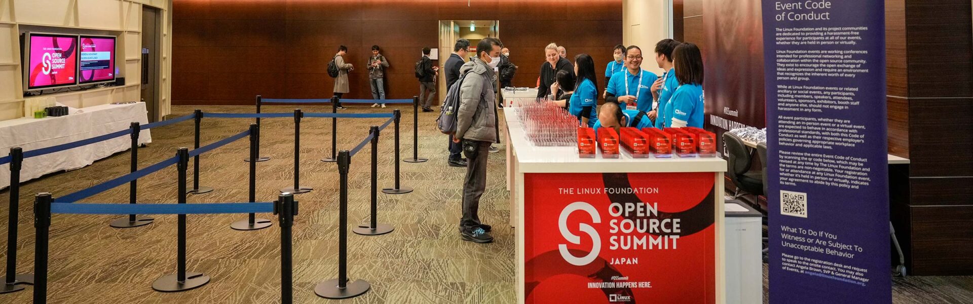 An attendee at the registration desk that says Open Soure Summit Japan.