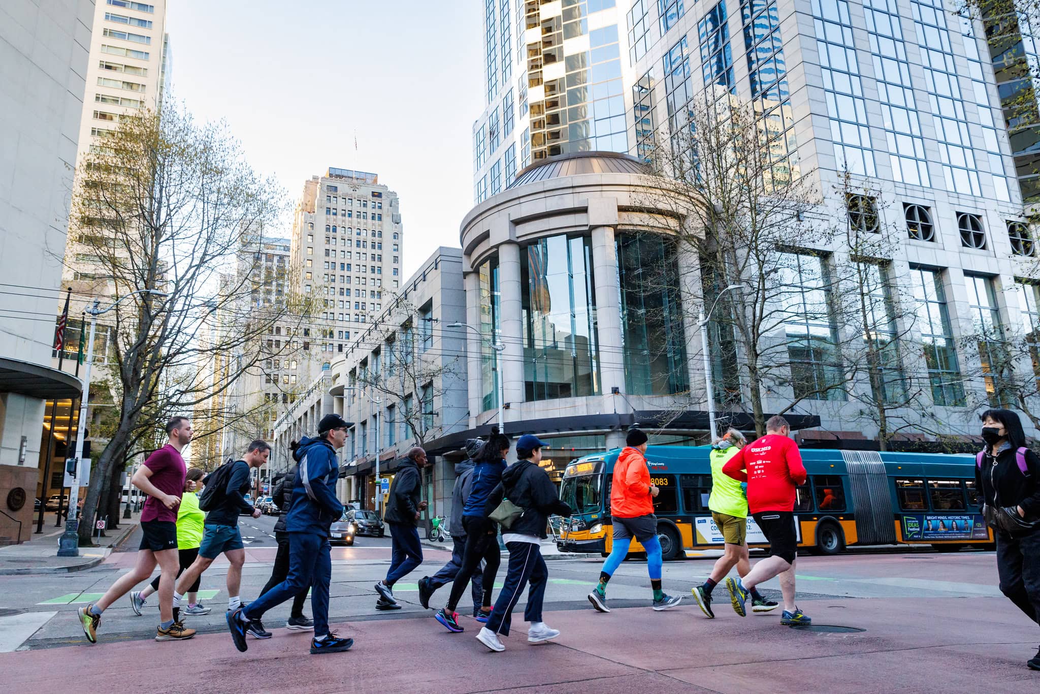 A group of people run through the city streets.