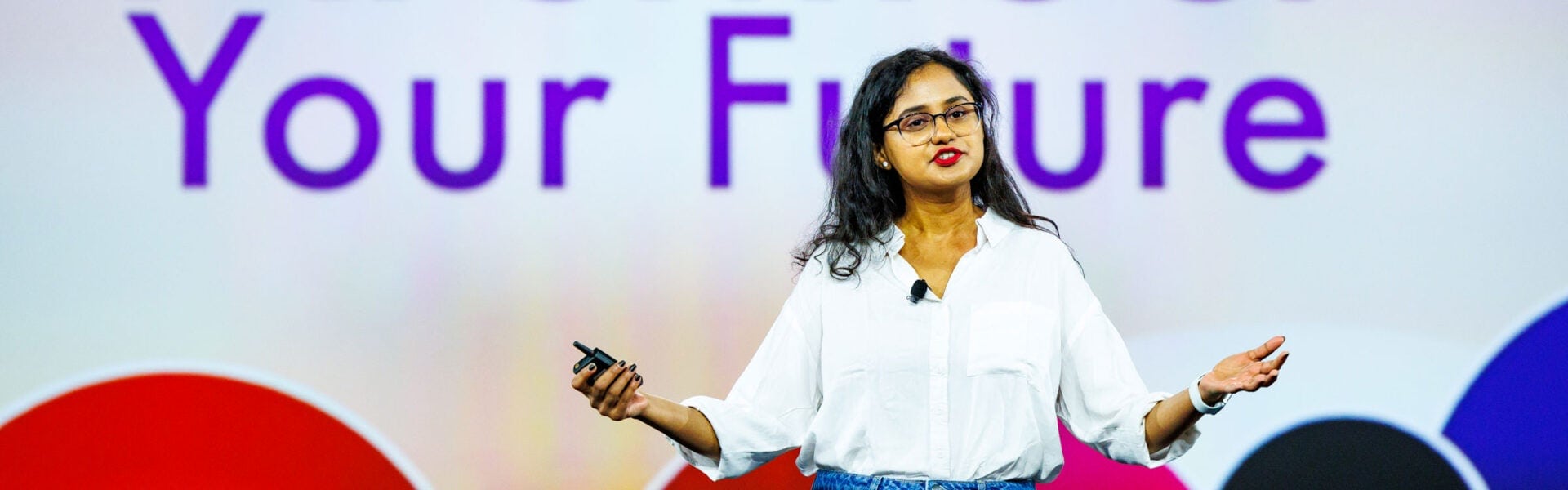 A woman on stage addressing the crowd, with the words "Your Future" behind her.