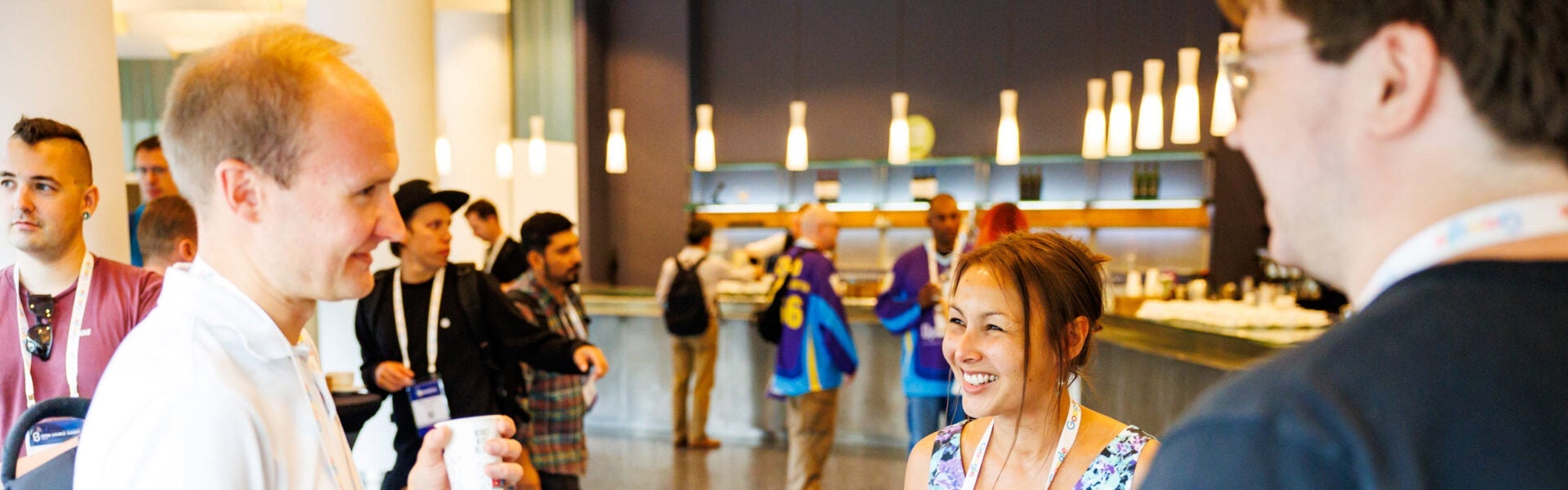 Attendees smiling and talking to one another.