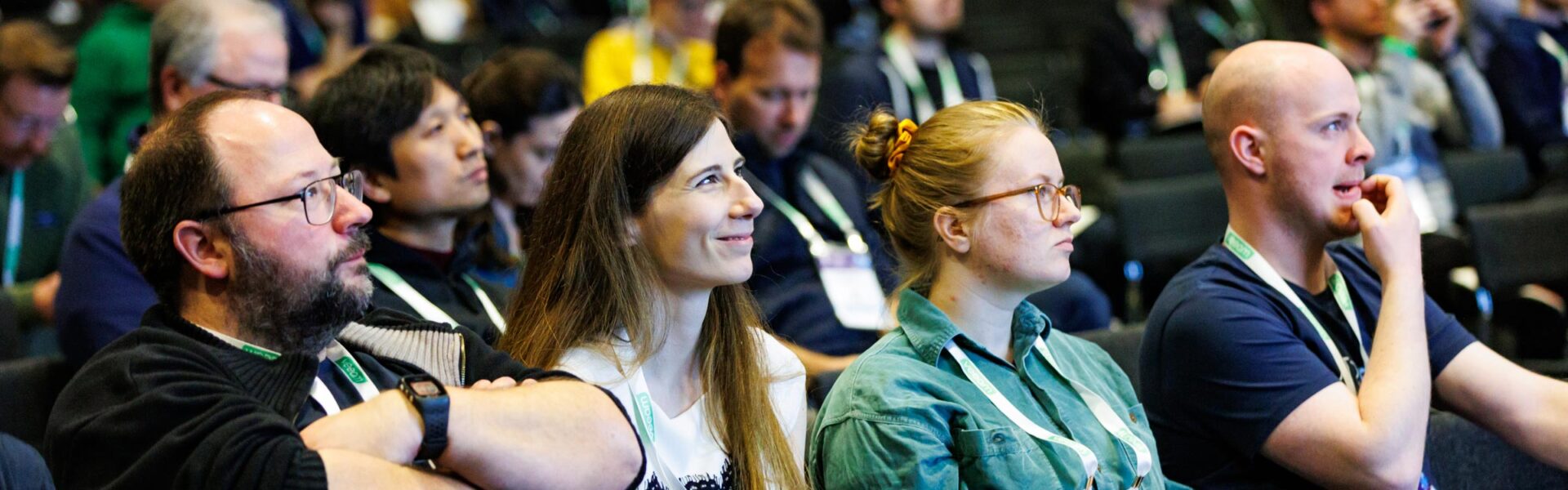 A smiling crowd seated at a session