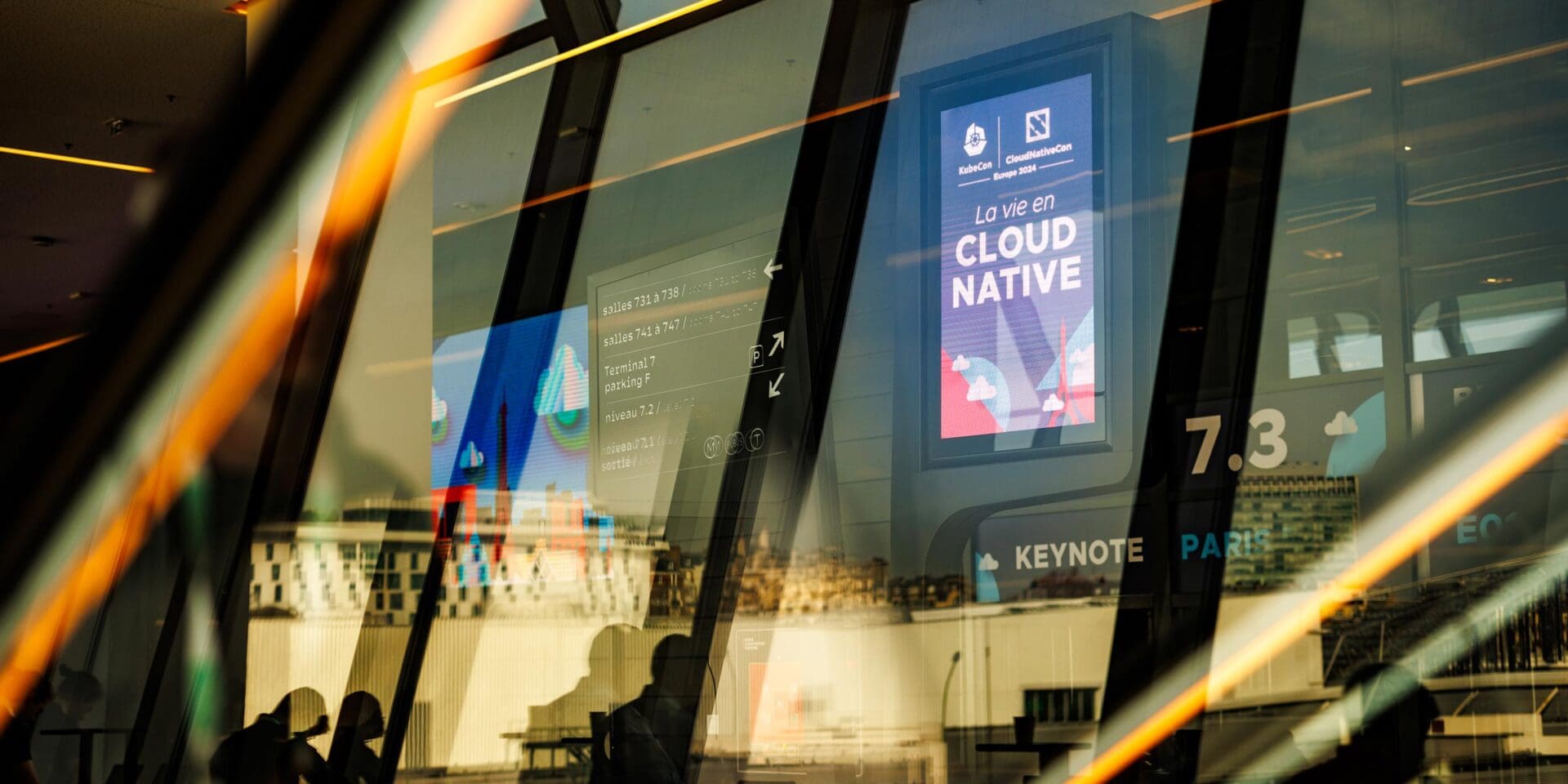 A photo taken through windows with reflections of event signage