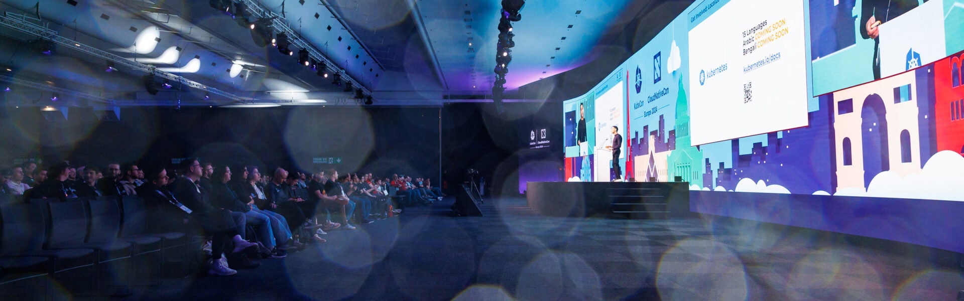 A wide angle view of the crowd & the stage at an event.