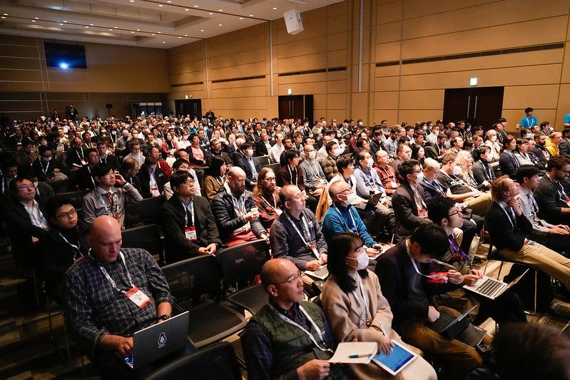 A large number of people seated in a ballroom.