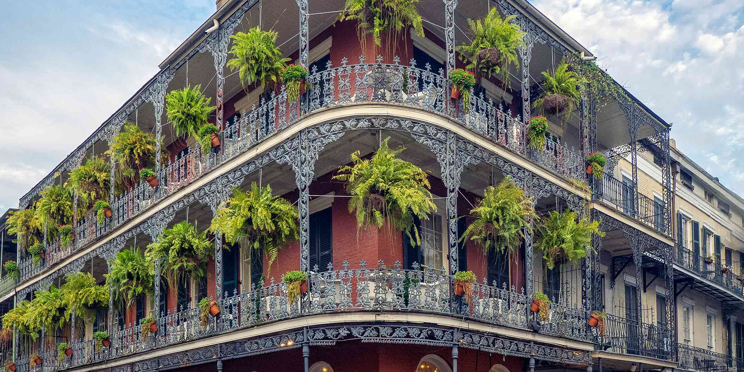 A brick building with plant lined, wrought iron, railings in New Orleans.