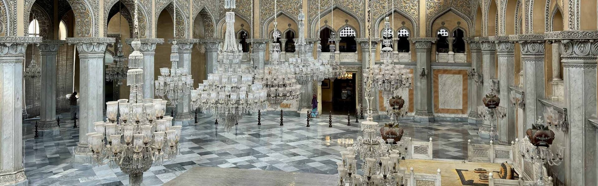 An intricately designed interior of a building with arches and chandeliers.