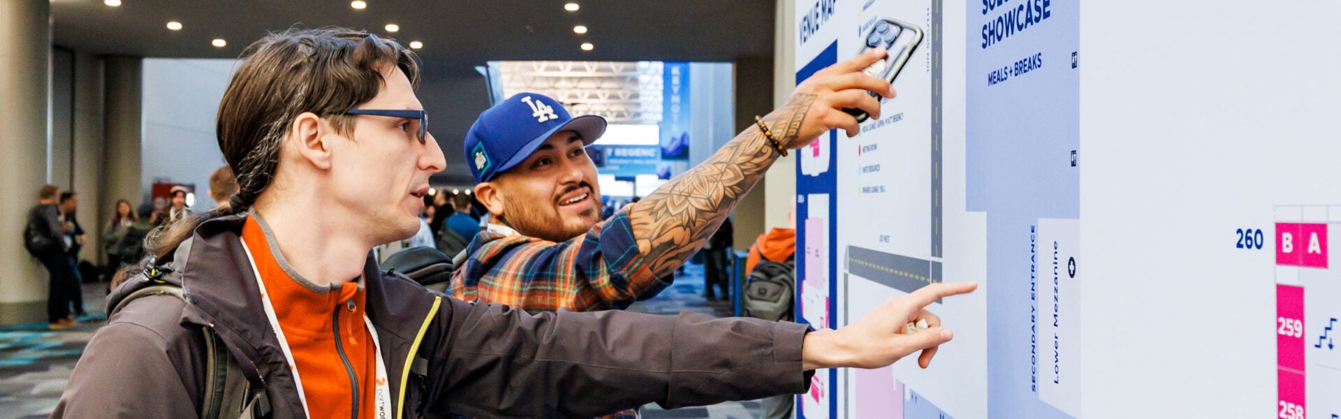 2 men pointing at the venue map.