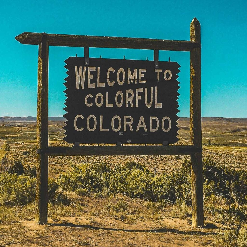 A wood sign that says "Welcome to Colorful Colorado."