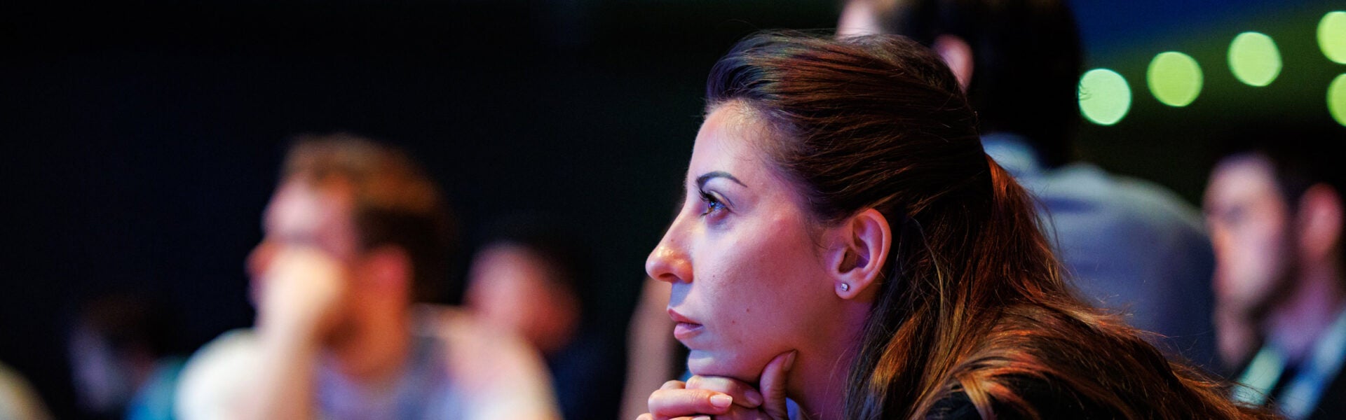 A woman leaning forward, focusing on the presentation.