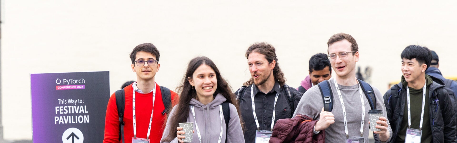 A group of attendees walking and smiling.