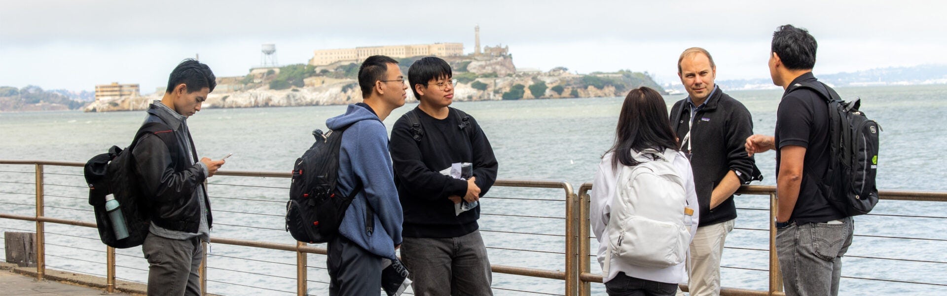 A group of people having a discussion by the waterfront.