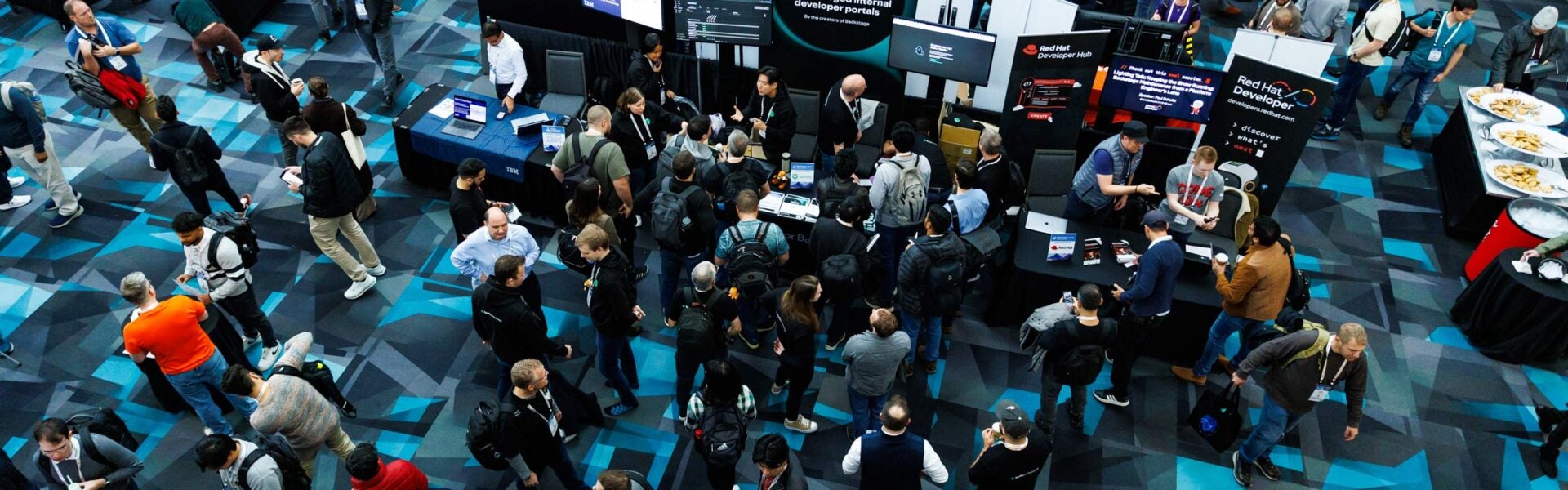 A photo taken from above of a large crowd near sponsor booths.