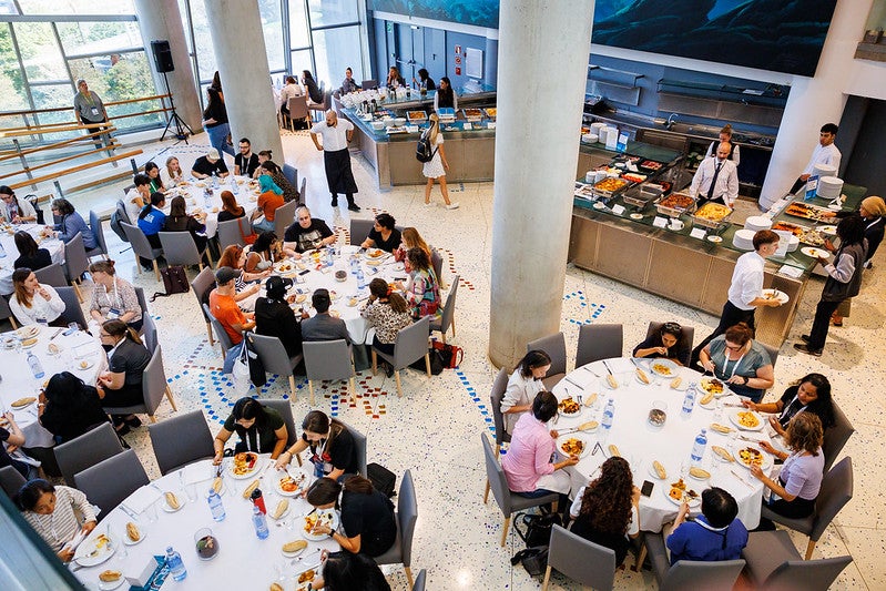 Round tables filled with attendees eating.