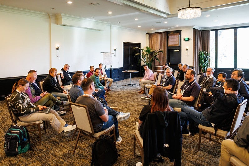 A group of attendees sitting in a circle talking.