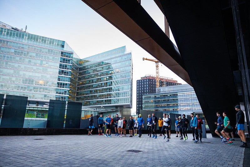 A group of people run through the city streets.