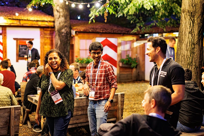3 event attendees walking through a reception talking and laughing.