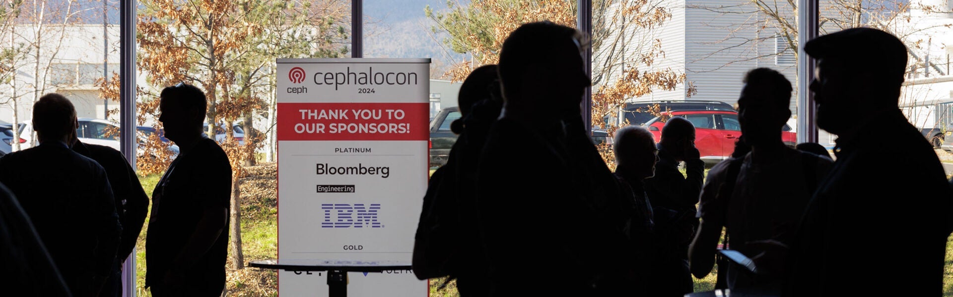 Silhouettes of attendees in front of a sign that reads "Thank you to our sponsors!"
