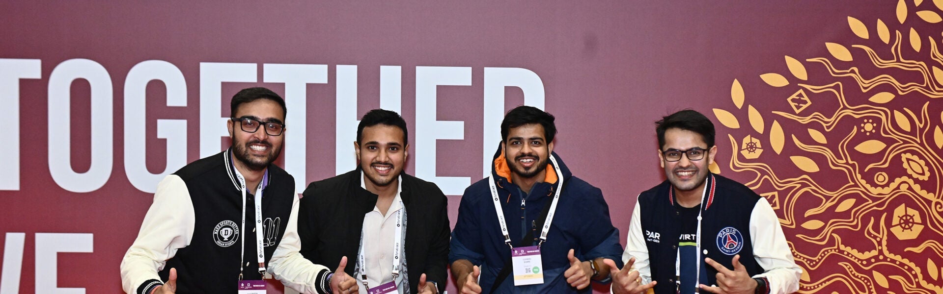 Four attendees stand together smiling.
