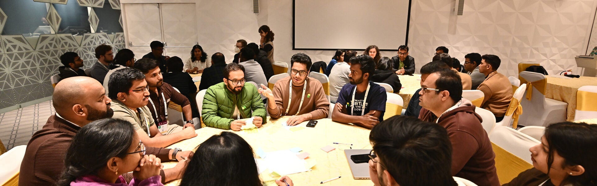 A group of attendees sitting at a round table having a discussion.