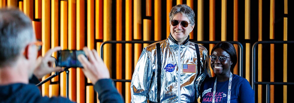 An astronaut and an event attendee posing for a portrait.