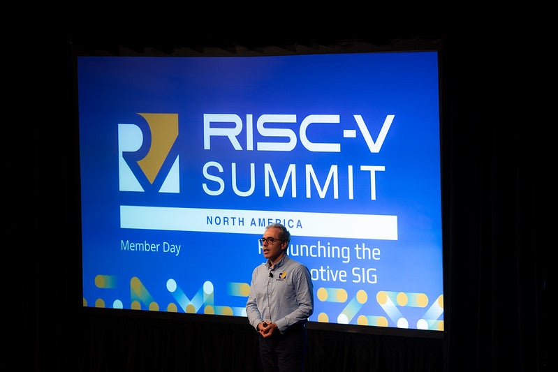 A man standing in front of a screen that reads "Risc-V Summit North America".