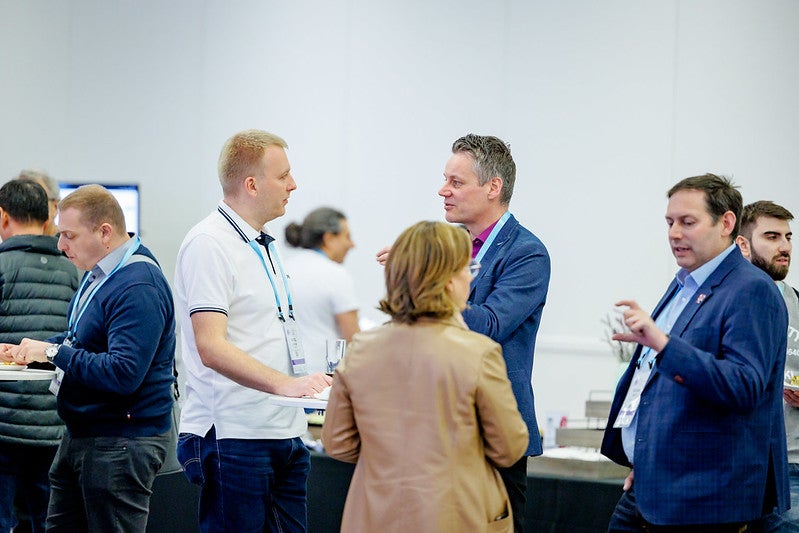 A group of people standing and talking.