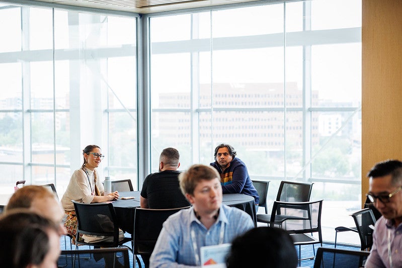 Attendees sitting at round tables having discussions.