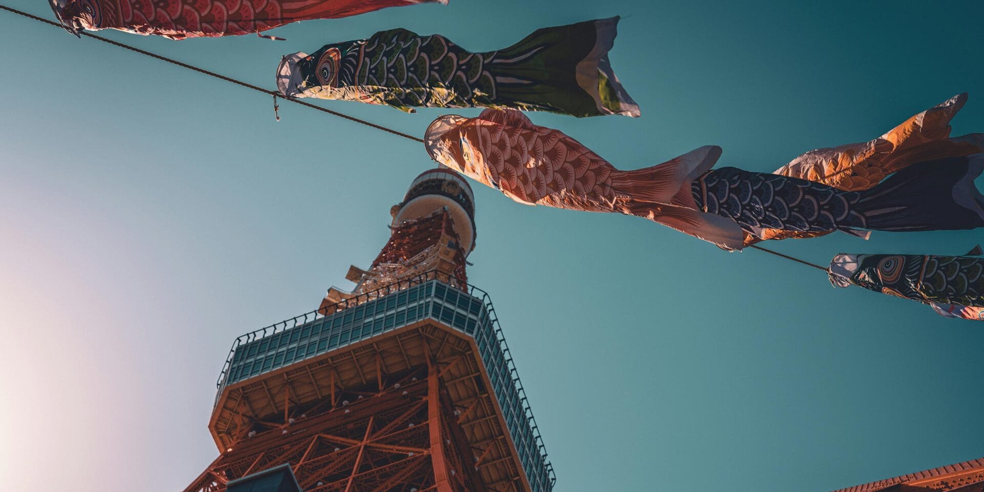 Fish streamers flying in the air in front of a building.