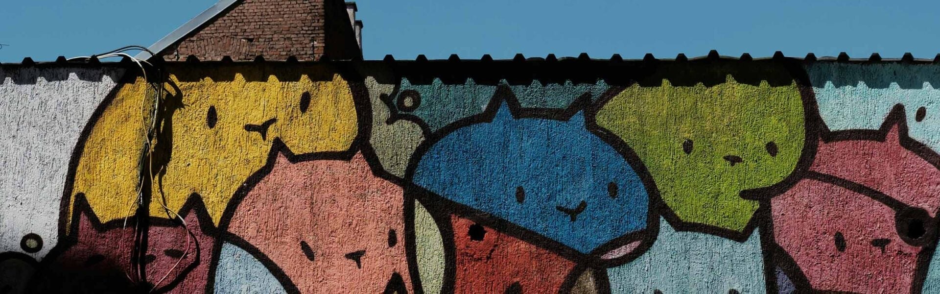 A colorful mural of cats on the outside of a building in Zagreb.