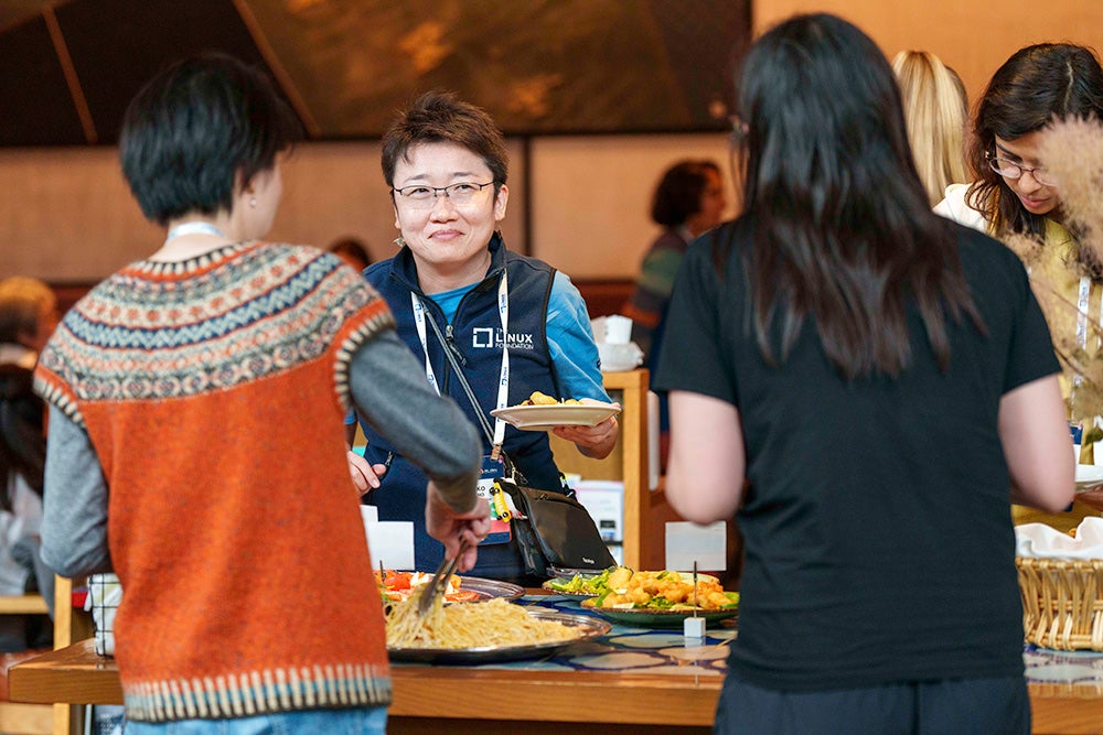A group of women going through a buffet setup, getting lunch.