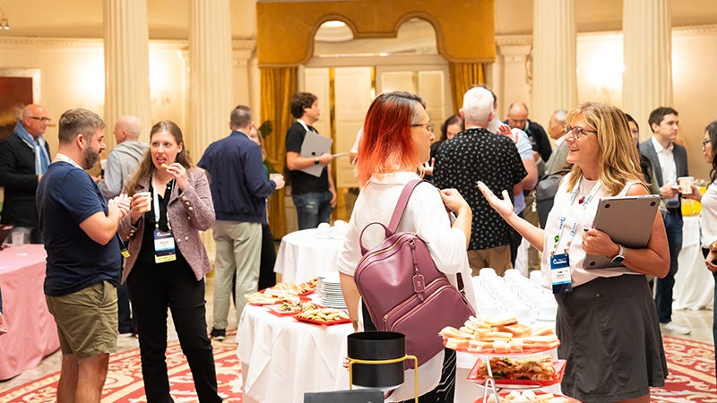 A room full of attendees talking and eating.