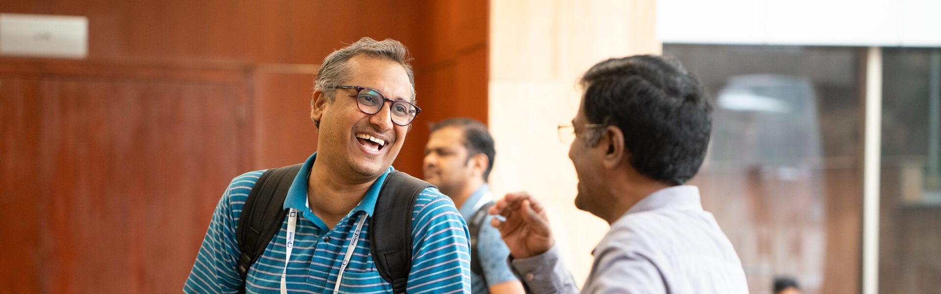 Attendees chatting and smiling during conference networking break