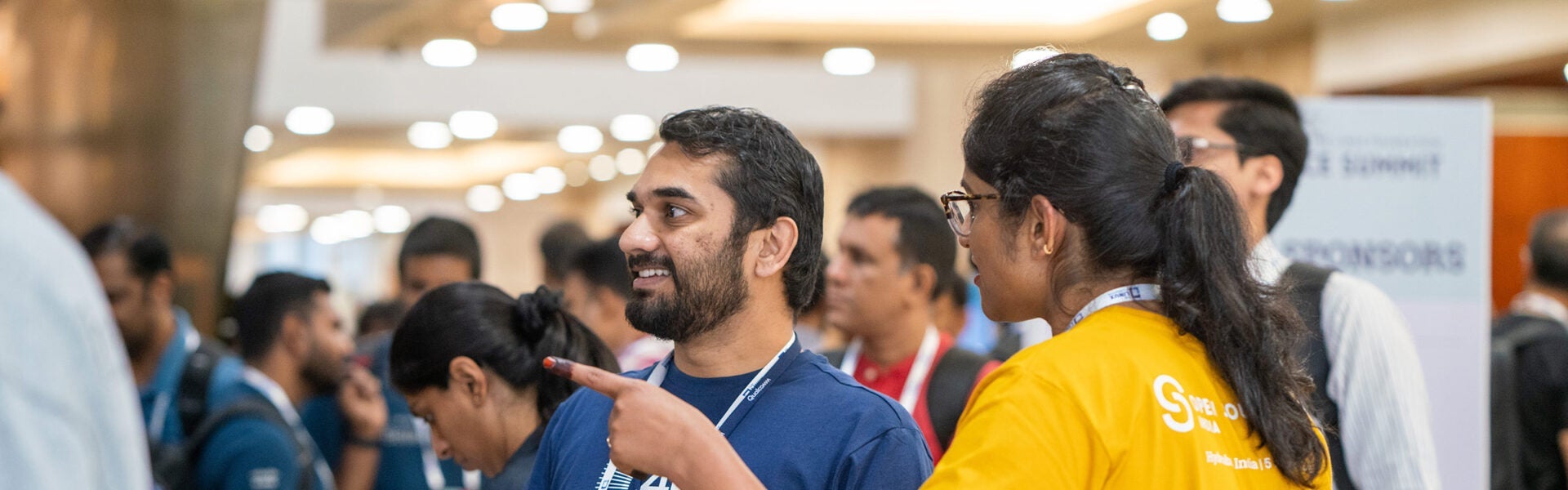 Close-up of conference attendee smiling while getting directions from another participant