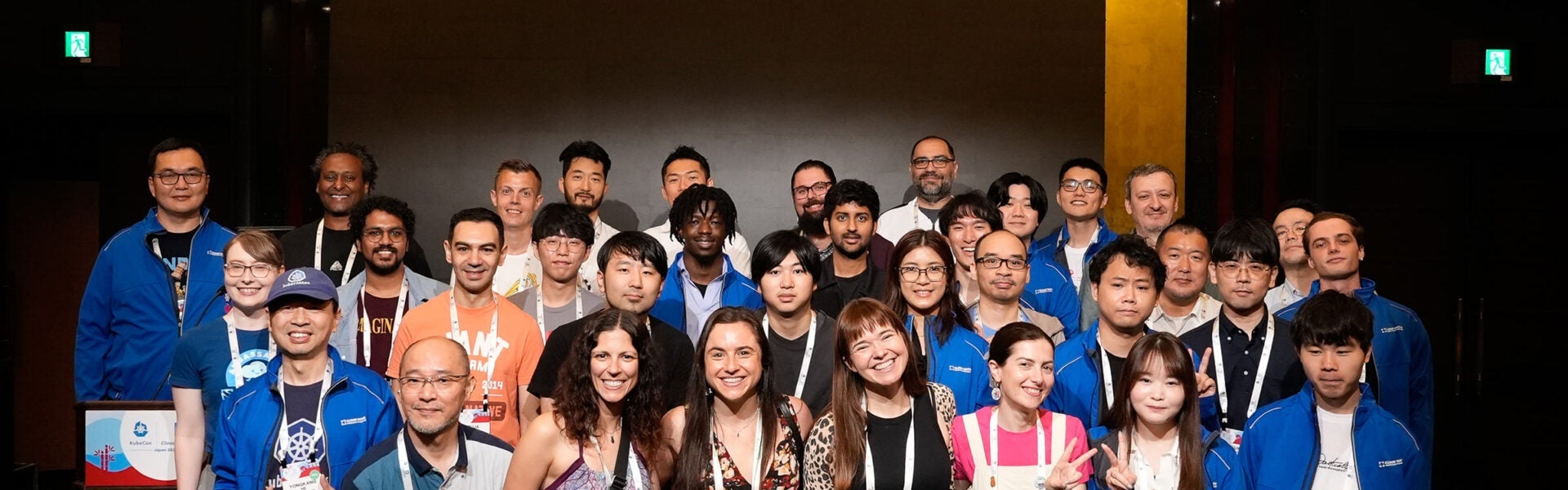A large group of conference participants posing together for a group photo indoors.