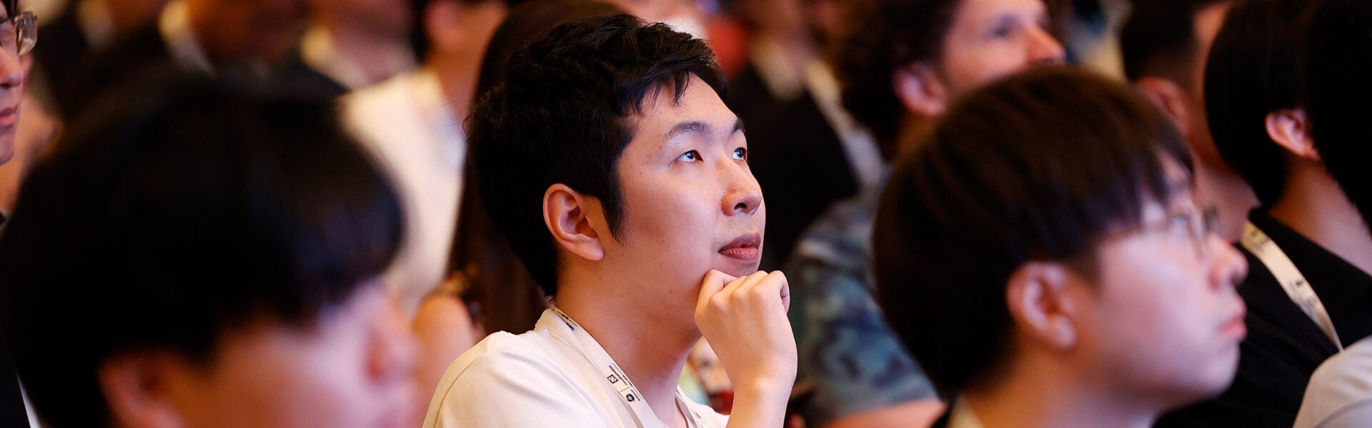 Audience members seated and listening attentively during a conference session.
