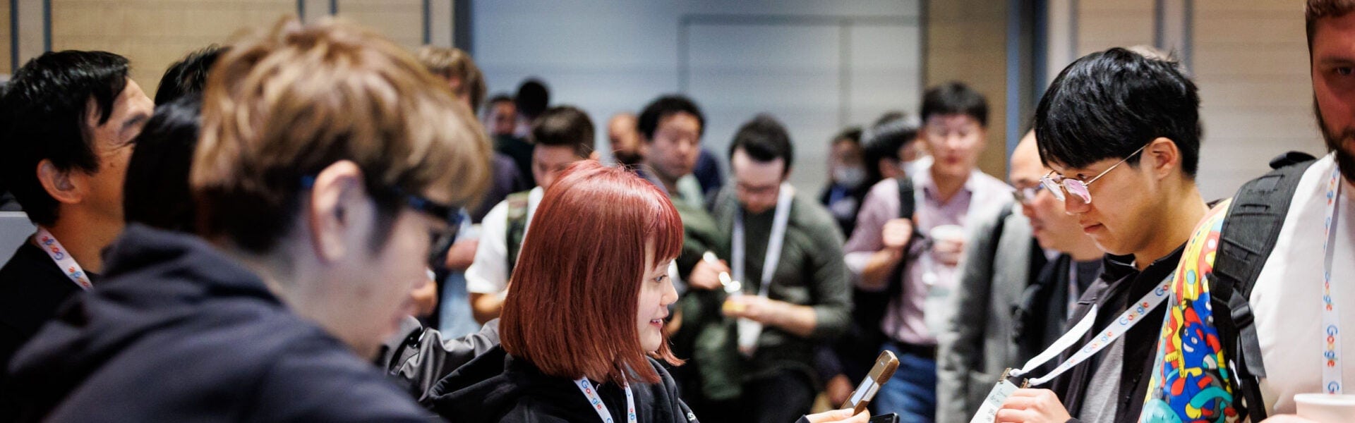 Attendees chatting and networking in a busy conference hallway.