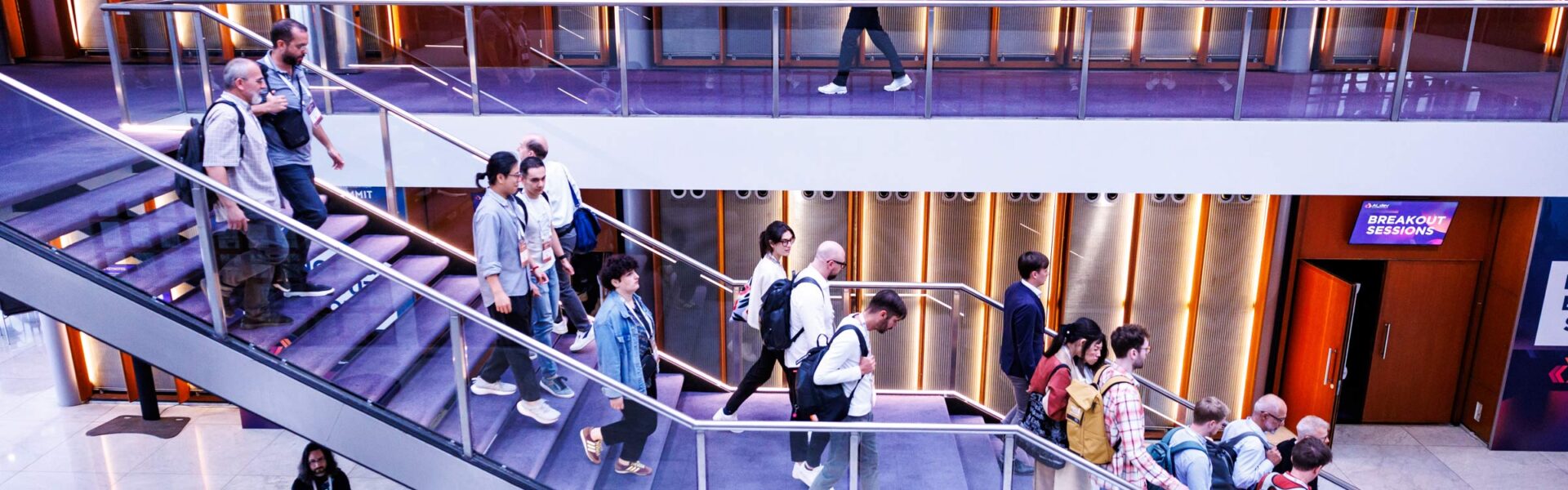Attendees walking down stairs at a conference venue
