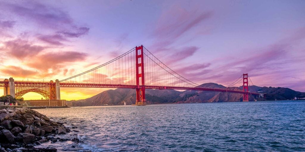 Golden Gate Bridge at sunset over the water.