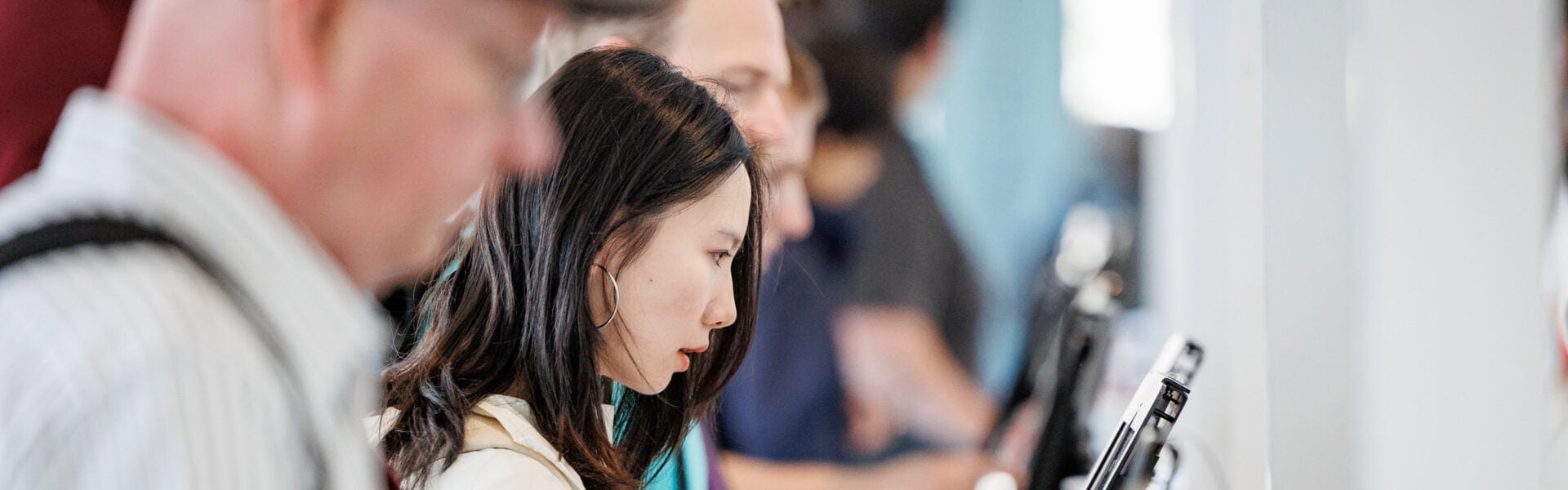 Attendees standing at kiosks registering for an event.