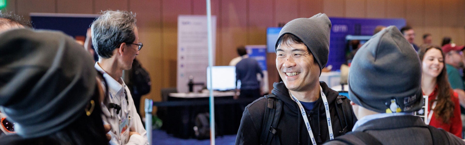 Conference attendees smiling and gathered in a networking area.